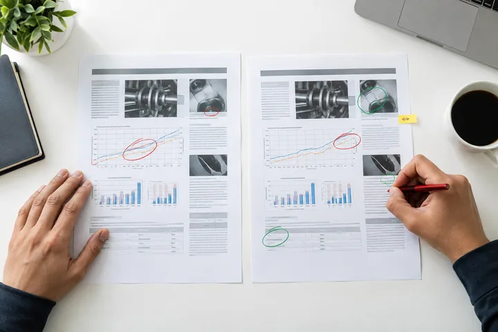 Zwei Arbeitskopien technischer Berichte mit Vergleichsmarkierungen