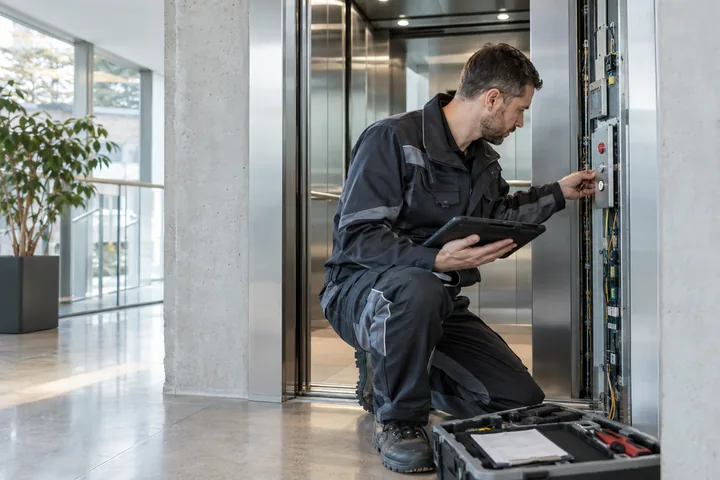 Servicetechniker dokumentiert eine Prüfung im Aufzugsschacht